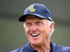 Greg Norman Breaks His Silence On LIV Golf’s Future Older man smiling, wearing a blue cap with a neon-green emblem on the front.