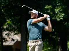 Wyndham Clark Blasts Crowd After Abuse at the US Open Male golfer in a teal shirt mid-swing with a golf club on a sunny course.