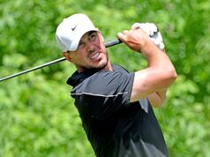 What Brooks Koepka’s Withdrawal Actually Means for the US Open Male golfer in a black shirt executing a backswing with a golf club, white Nike cap, light glove, on a lush green backdrop.