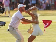 Wyndham Clark’s Putter Switch Sparks Record-Breaking Performance Couple dancing together on a sunny grassy field while a TV camera films them from the left.