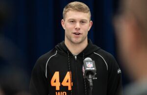 Awesome Moment College Star Is Drafted While Playing Golf Athlete in a black hoodie with orange '44' speaks at a press conference, microphone with NFL logo in front of him.