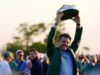 Rory McIlroy’s Decision Has Golf Fans Criticizing PGA Tour Man in a green jacket proudly raises a large circular model boat above his head at an outdoor crowd event, smiling for the camera.