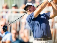 LIV Golf Star Admits Why He Joined Controversial League Male golfer in a navy shirt swings a club during a sunny tournament, crowd blurred in the background at the course.