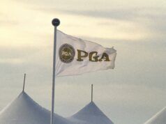 PGA Tour Legend And Eight-Time Winner Dead at 85 White flag bearing a circular PGA logo waves atop a pole beside white event tents under a pale sky.