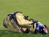 TaylorMade Qi4D Fairways: Tour vs Core — The Real Difference Tan leather golf bag with blue straps resting on a grassy golf course.