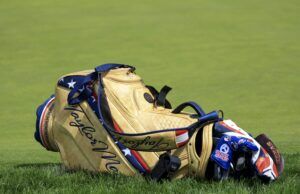 TaylorMade Qi4D Fairways: Tour vs Core — The Real Difference Tan leather golf bag with blue straps resting on a grassy golf course.